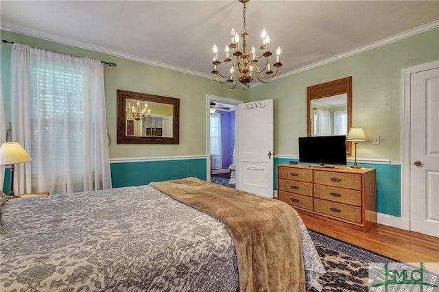 bedroom featuring ornamental molding, a notable chandelier, and wood finished floors