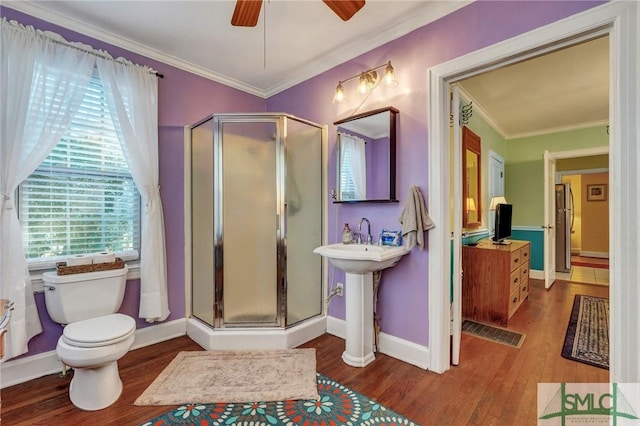 full bath featuring a shower stall, crown molding, and wood finished floors