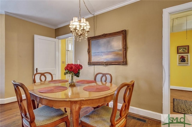 dining space featuring baseboards, crown molding, and wood finished floors