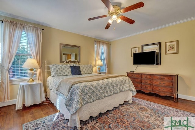 bedroom with ornamental molding, multiple windows, and wood-type flooring