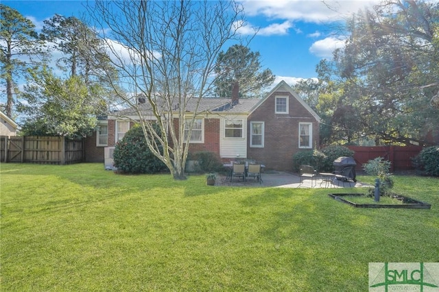 back of property with a patio area, brick siding, fence, and a lawn