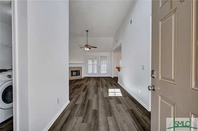 laundry room with baseboards, a tile fireplace, ceiling fan, washer / clothes dryer, and wood finished floors