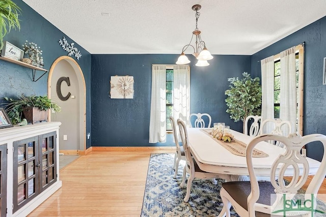 720 Old Dixie Hwy S, Springfield, GA 31329 - dining area with baseboards, arched walkways, wood finished floors, a textured ceiling, and a chandelier