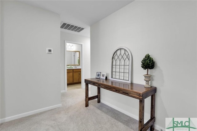 home office with light colored carpet, visible vents, and baseboards