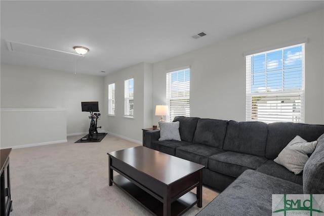 living room with baseboards, attic access, visible vents, and light colored carpet