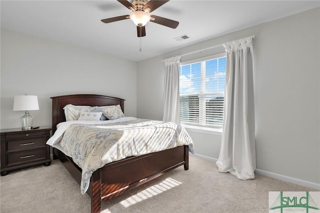 bedroom featuring baseboards, a ceiling fan, visible vents, and light colored carpet