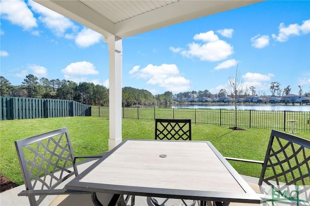 view of patio / terrace with a water view, a fenced backyard, and outdoor dining area