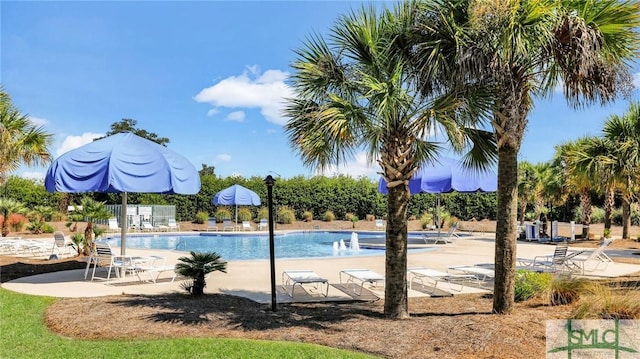 pool with a patio and fence