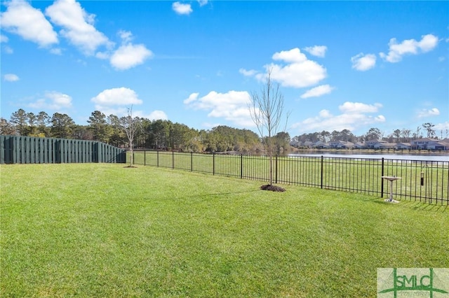 view of yard featuring a water view and a fenced backyard