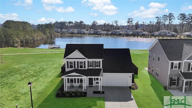 view of front of home with concrete driveway, a water view, an attached garage, a front yard, and a residential view