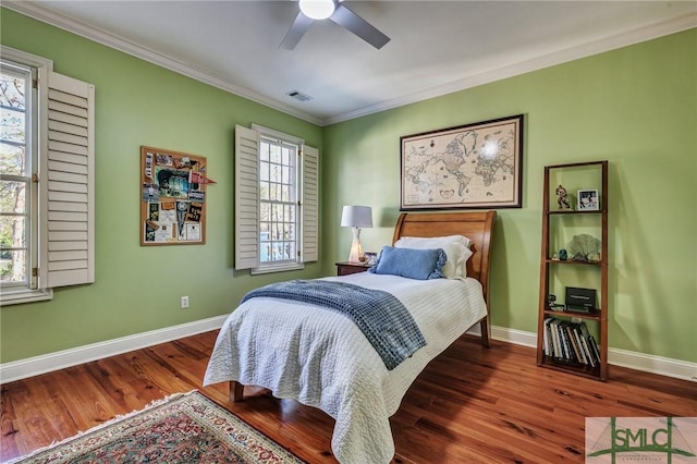 bedroom featuring baseboards, visible vents, wood finished floors, and ornamental molding