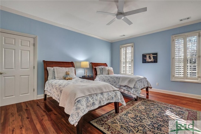 bedroom with baseboards, crown molding, visible vents, and wood finished floors