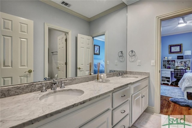 ensuite bathroom with ensuite bath, visible vents, a sink, and ornamental molding