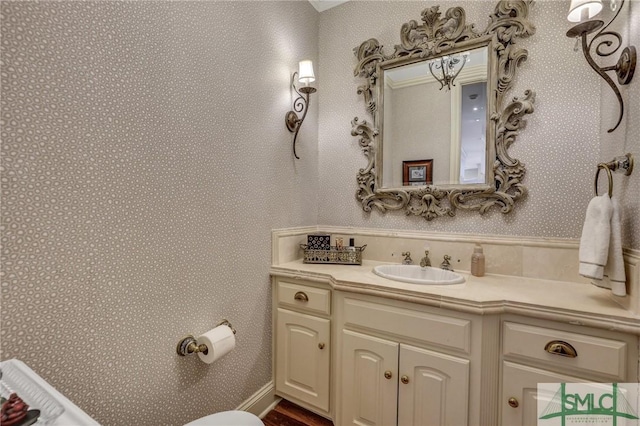 bathroom featuring vanity and wallpapered walls