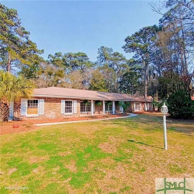 single story home featuring a front yard and brick siding