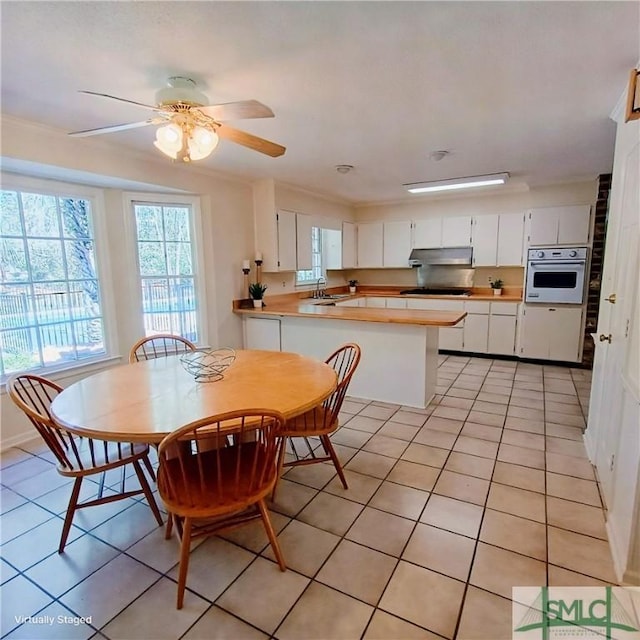 dining room featuring light tile patterned floors, a ceiling fan, and crown molding