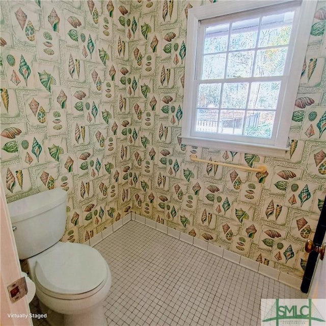 bathroom with baseboards, tile patterned flooring, toilet, and wallpapered walls