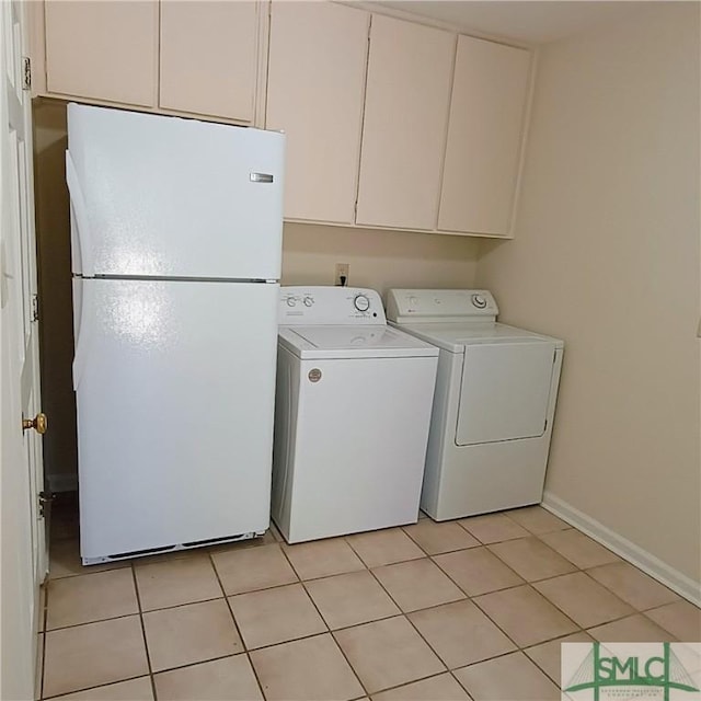 laundry area with baseboards, cabinet space, washing machine and clothes dryer, and light tile patterned floors