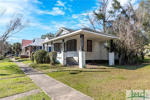 view of side of home with a porch and a yard