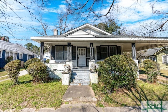 bungalow-style house with covered porch and a chimney