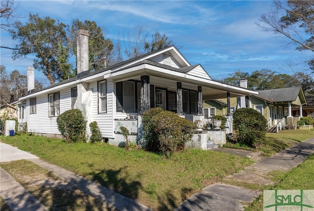 view of side of home with an attached carport, covered porch, a lawn, and crawl space