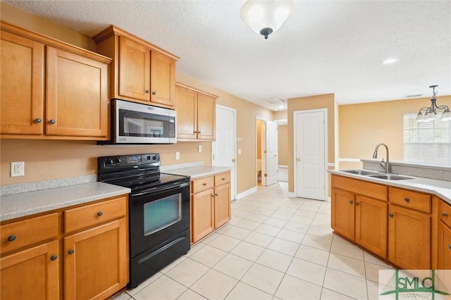 kitchen featuring a textured ceiling, a sink, light countertops, black electric range oven, and stainless steel microwave