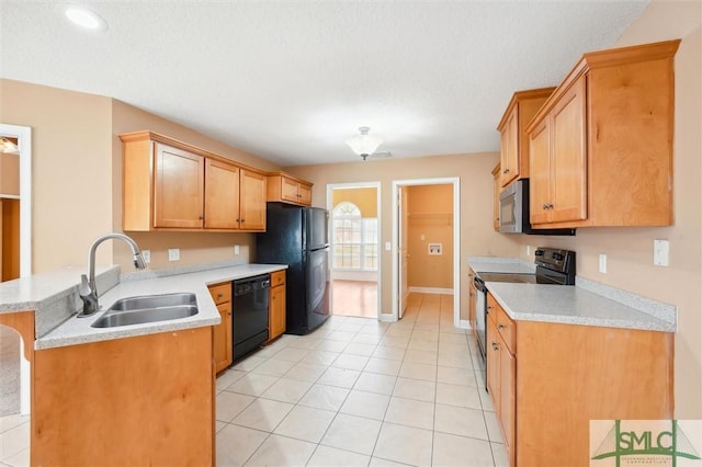 kitchen featuring black appliances, a peninsula, a sink, and light countertops