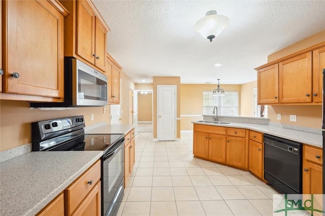 kitchen featuring a peninsula, light countertops, black appliances, a sink, and light tile patterned flooring