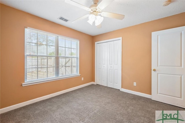 unfurnished bedroom with a closet, visible vents, a ceiling fan, carpet flooring, and baseboards