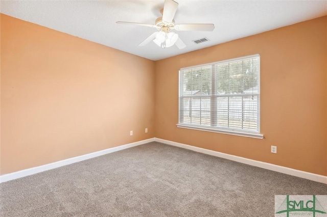 unfurnished room with carpet, visible vents, ceiling fan, and baseboards