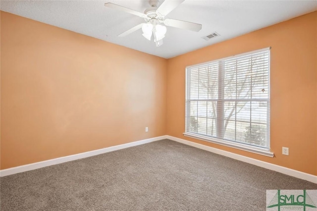 spare room with carpet flooring, visible vents, and baseboards