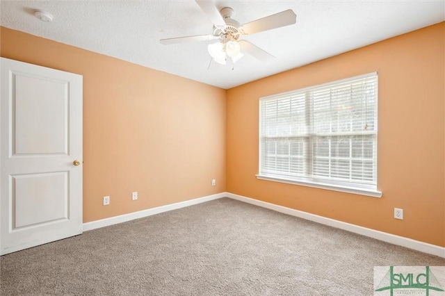 carpeted spare room with a ceiling fan, a textured ceiling, and baseboards