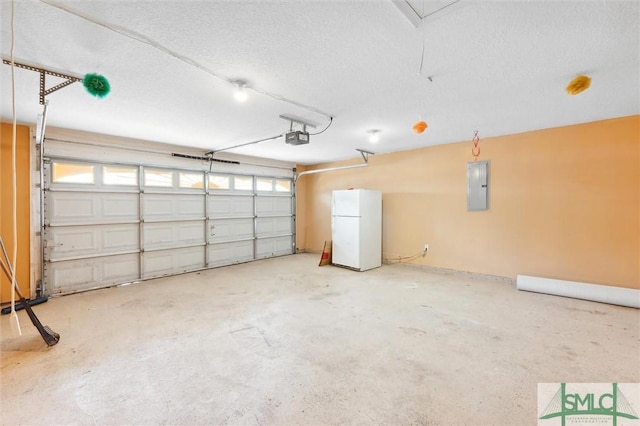 garage with a garage door opener, freestanding refrigerator, and electric panel