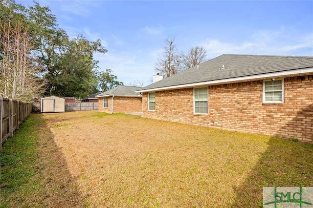 view of yard featuring a shed, a fenced backyard, and an outdoor structure