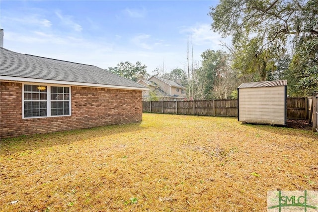 view of yard with a storage shed, a fenced backyard, and an outbuilding