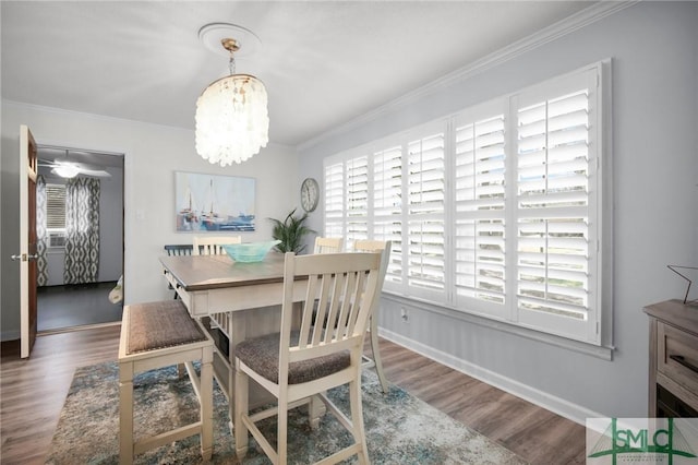 dining room with plenty of natural light, crown molding, and wood finished floors