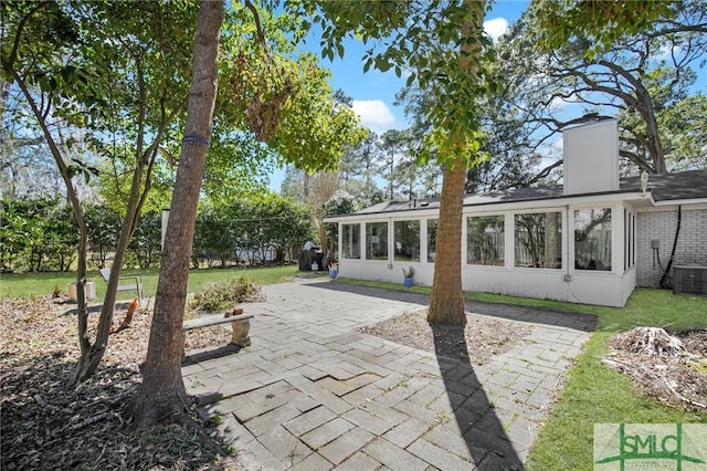 back of property featuring a patio area, a yard, fence, and brick siding