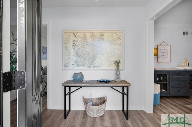 home office featuring baseboards, visible vents, and wood finished floors