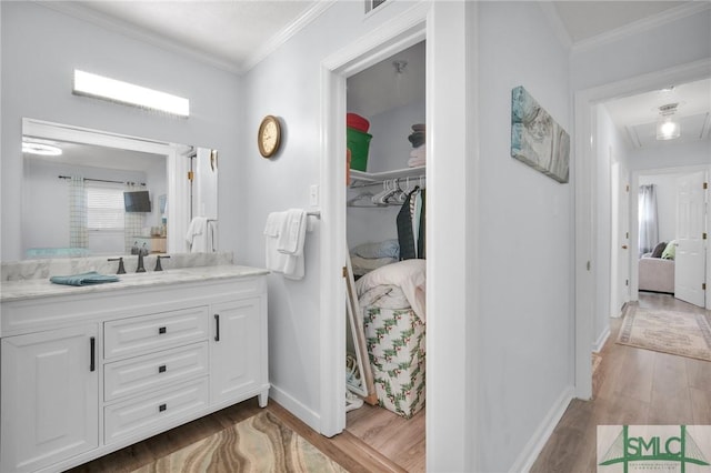 full bath with baseboards, ornamental molding, wood finished floors, and vanity