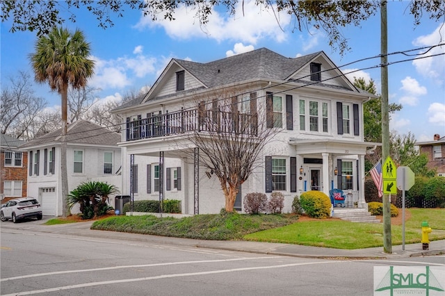 202 E 49th St, Savannah, GA 31405 - view of front facade with a balcony, brick siding, and a front lawn