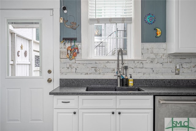 kitchen featuring a sink, dark countertops, decorative backsplash, and dishwasher