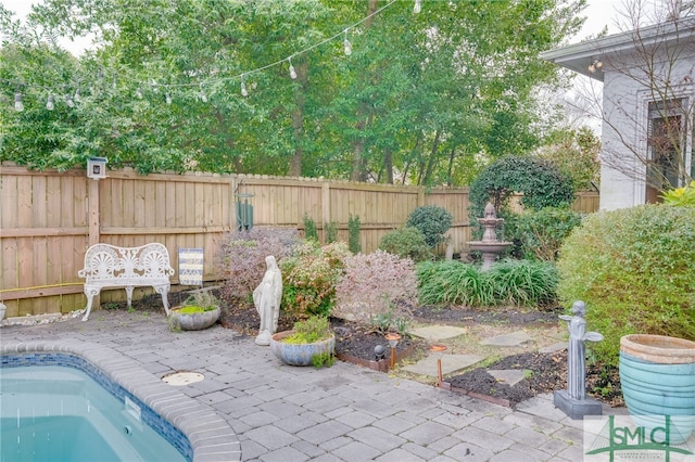 view of swimming pool featuring a patio area and fence