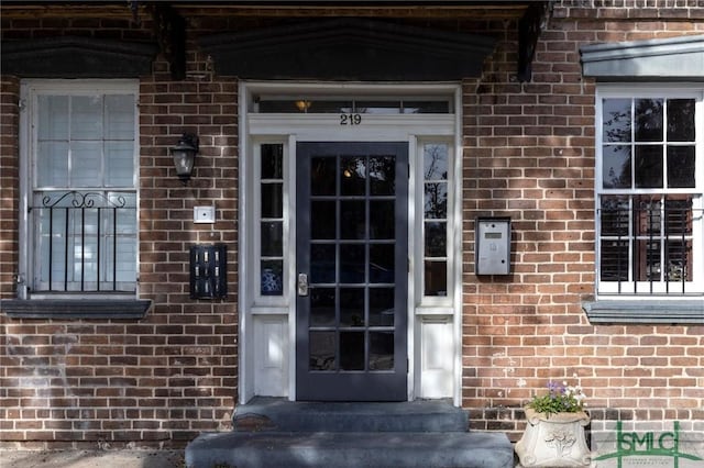 property entrance featuring brick siding