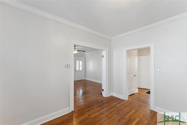 unfurnished room featuring wood-type flooring, ornamental molding, and baseboards