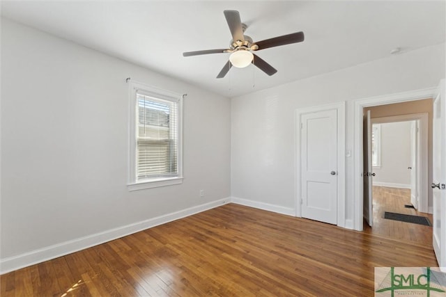 empty room with hardwood / wood-style flooring, ceiling fan, and baseboards