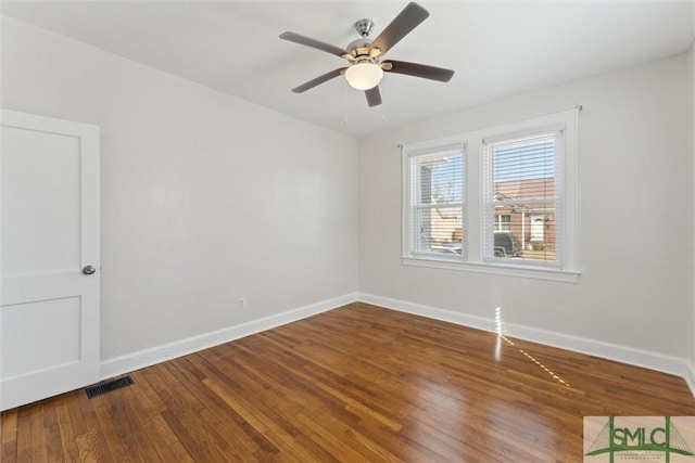 unfurnished room with hardwood / wood-style flooring, baseboards, visible vents, and ceiling fan