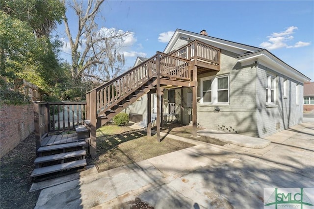 back of property with crawl space, stairs, a deck, and brick siding