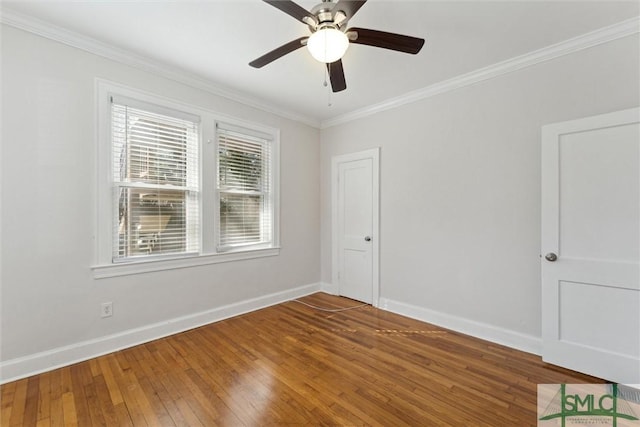 spare room with ceiling fan, ornamental molding, wood-type flooring, and baseboards