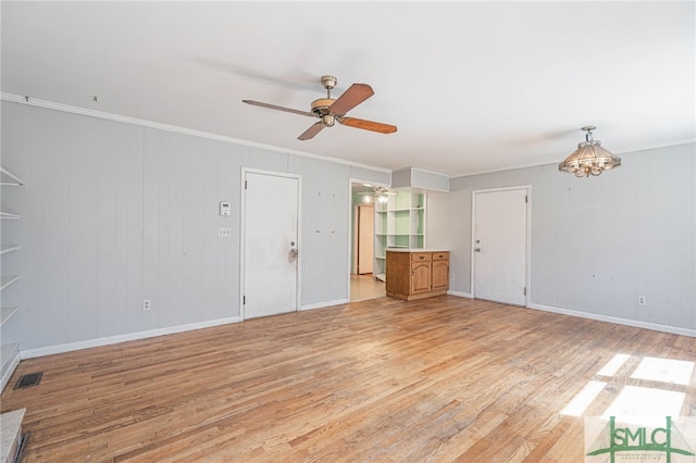 unfurnished living room featuring baseboards, visible vents, a ceiling fan, crown molding, and light wood-type flooring