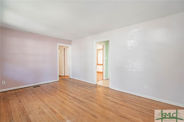 unfurnished room with light wood-type flooring, baseboards, and visible vents